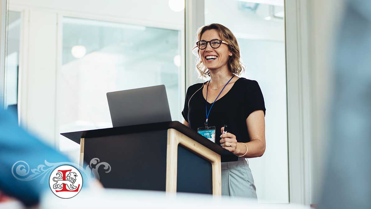 Businesswoman standing at podium with laptop giving a speech