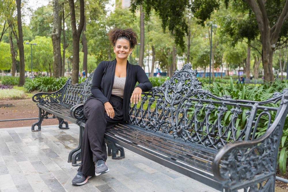 Girl smiling and sitting on bench in a professional attire